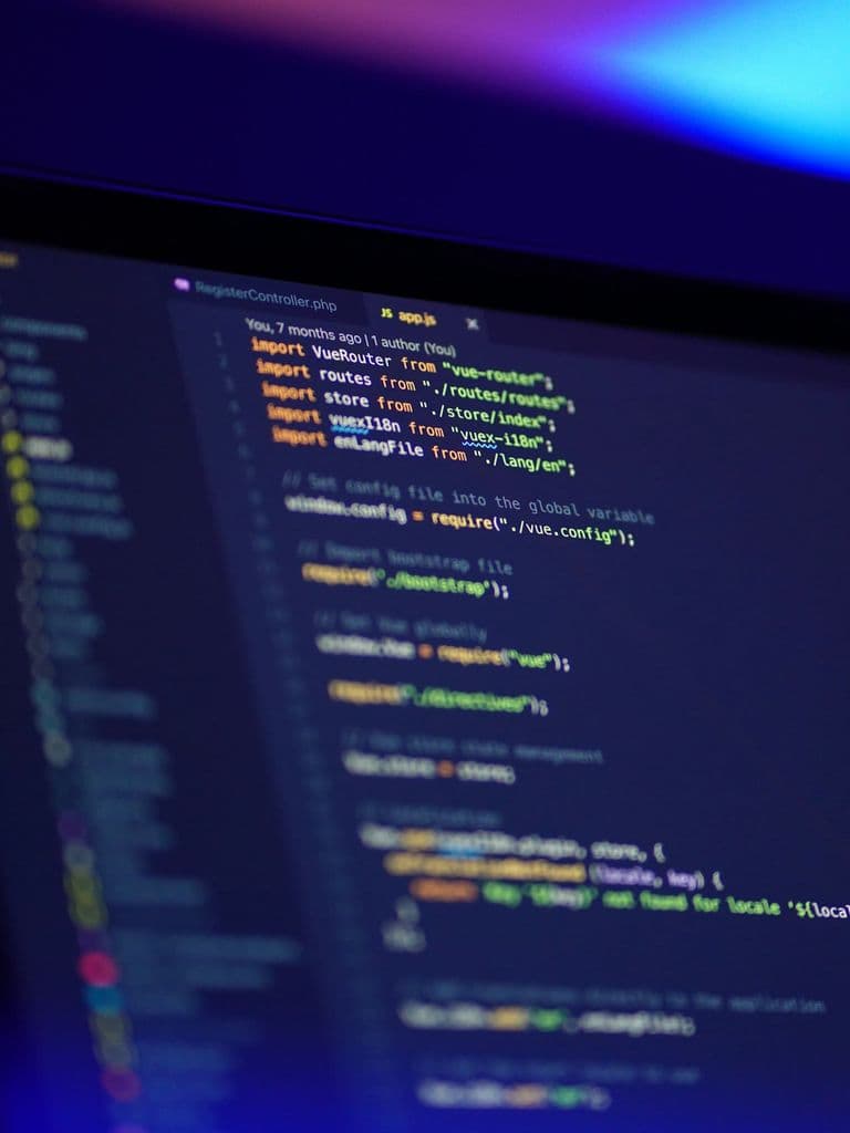 Code on a laptop screen in a dark room, representing cybersecurity essentials