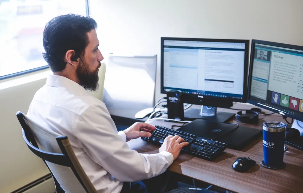 IT engineer proactively monitoring systems on dual displays