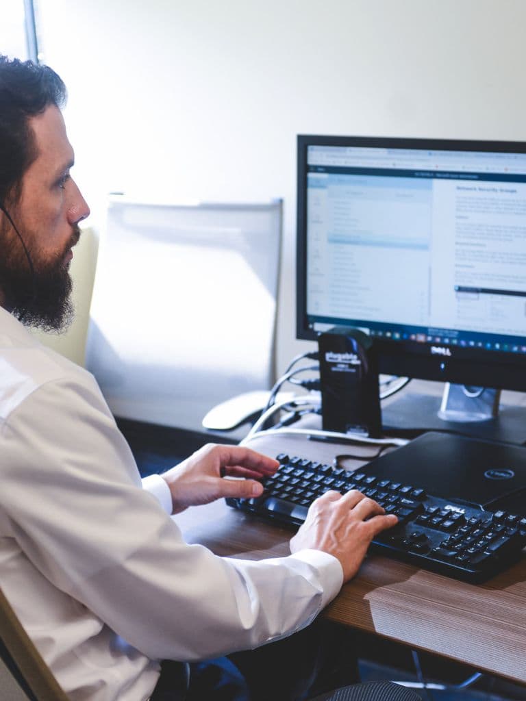 IT engineer proactively monitoring systems on dual displays