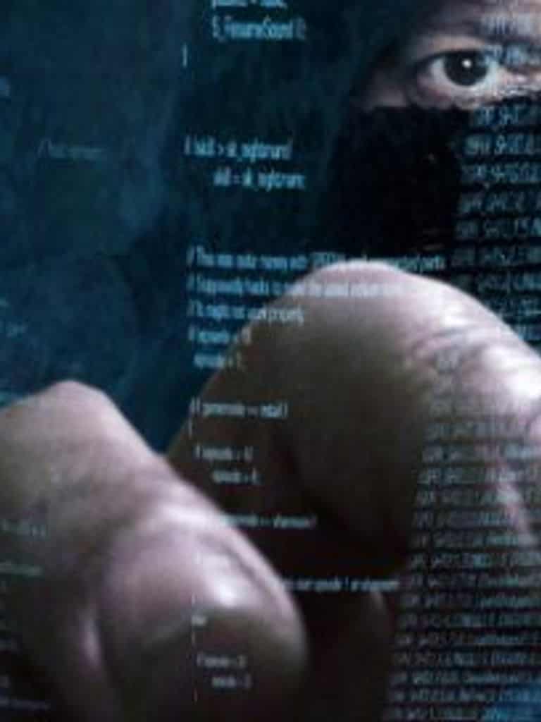 hacker going through code to launch a cyberattack against your business