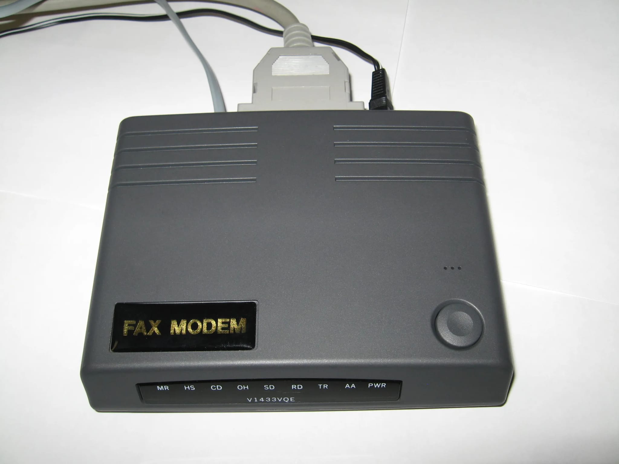 A gray external dial-up fax modem with cables attached, photographed on a plain white background.