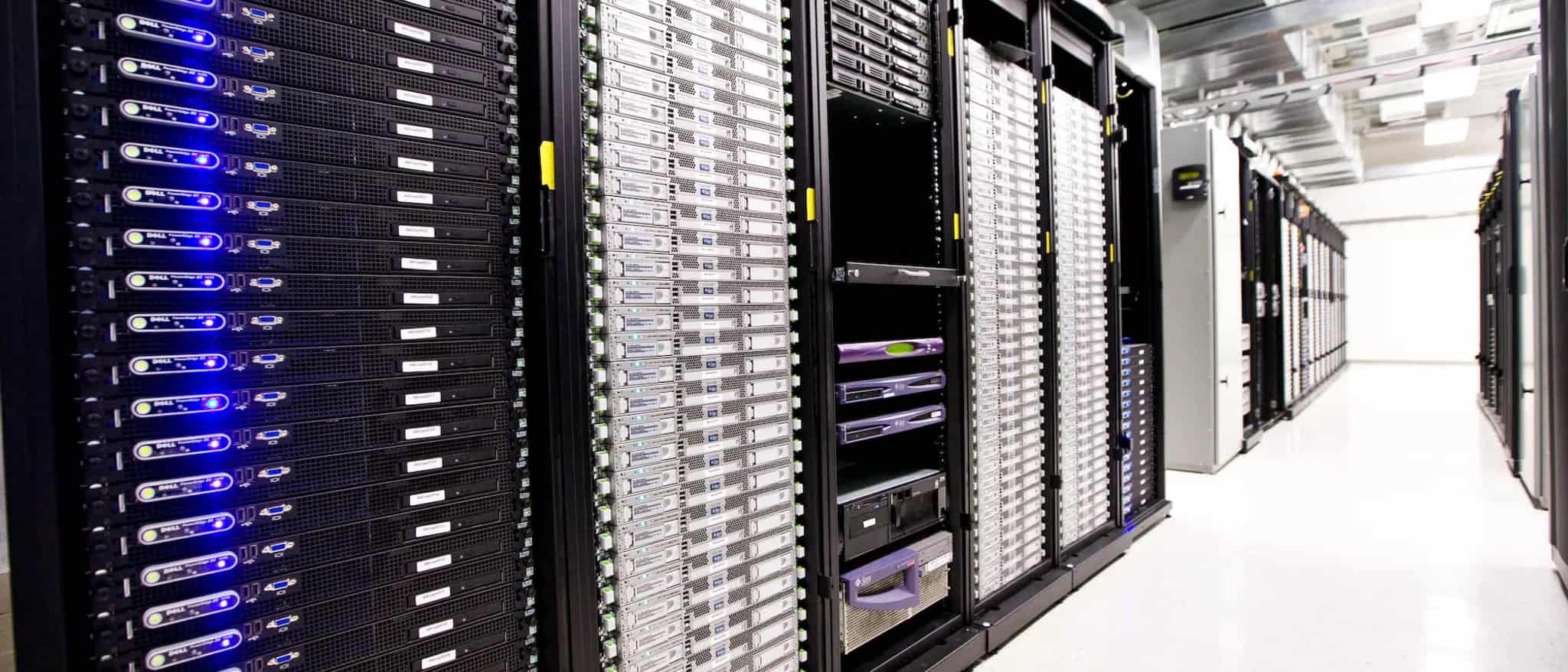 A row of server racks with glowing blue and white status lights lining a data center aisle.