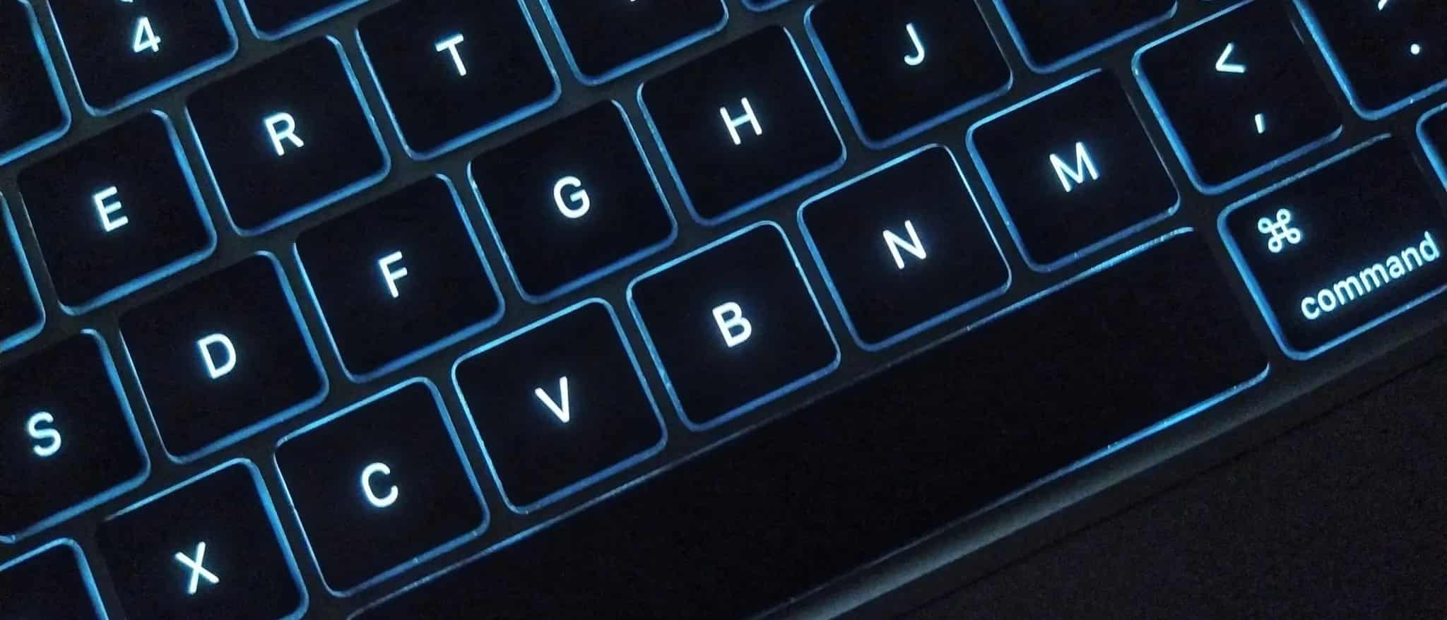 A close-up of a backlit MacBook keyboard highlighting the command key.