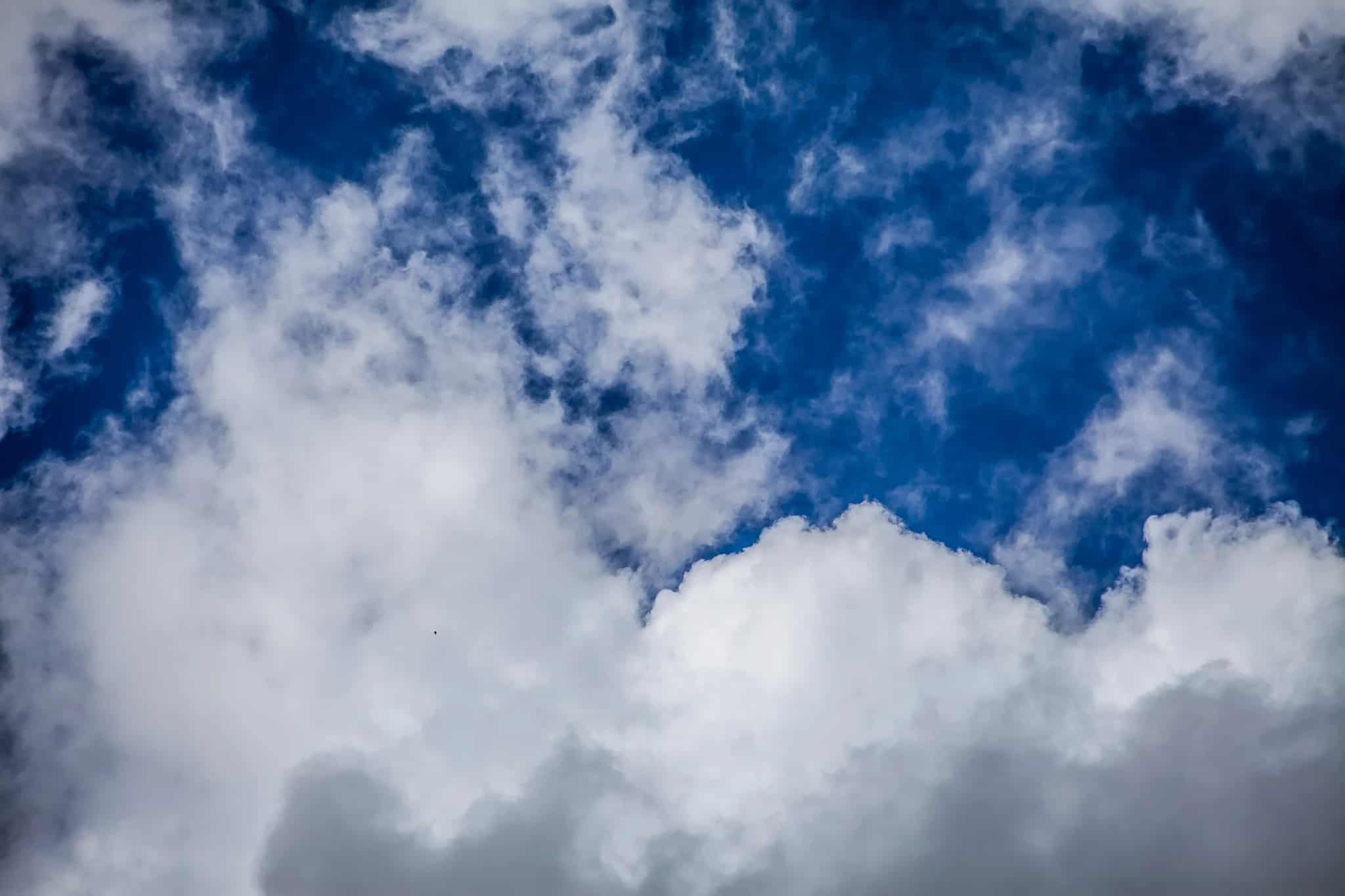 A bright blue sky partially covered by large white clouds.
