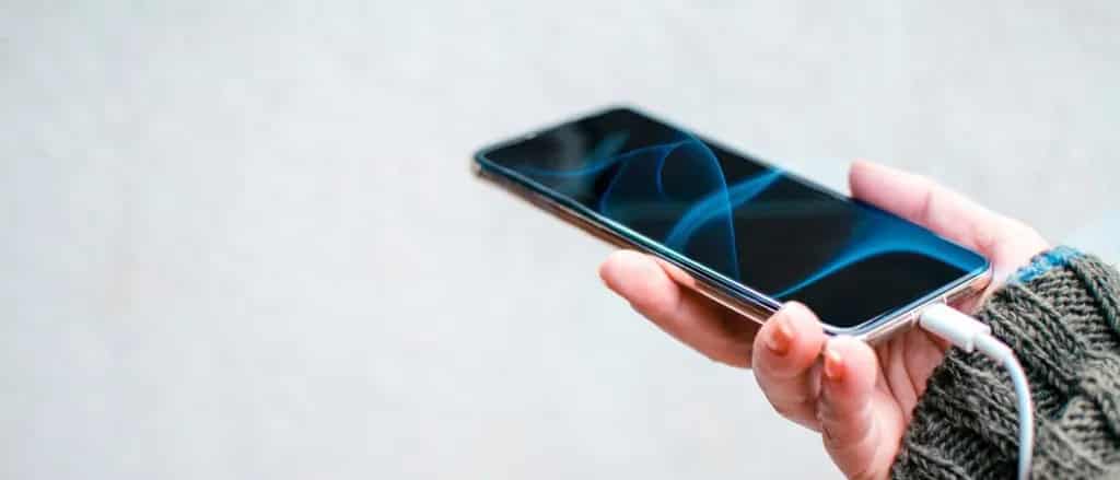 Android user with USB chord plugged in to cellphone