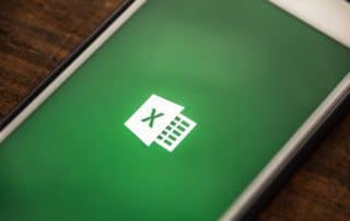 phone on desk showing Microsoft Excel logo on screen
