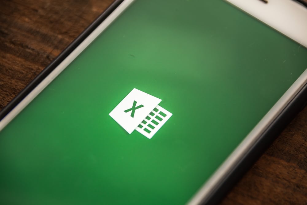 phone on desk showing Microsoft Excel logo on screen