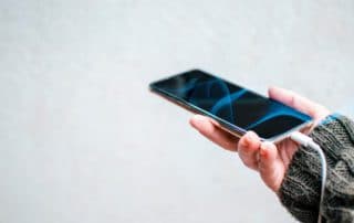 Android user with USB chord plugged in to cellphone