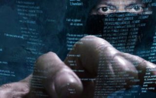 hacker going through code to launch a cyberattack against your business